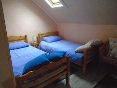 Cette chambre avec 3 lits simple